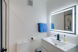 a white bathroom with a sink and a mirror at 4 Mi to Smithsonian Museums Modern DC Condo! in Washington +17 photos