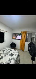 a bedroom with a bed and a flat screen tv at Linda y acogedora habitación in Floridablanca +8 photos
