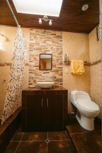 a bathroom with a white toilet and a sink at Yuyay Wasi Bungalows in Urubamba