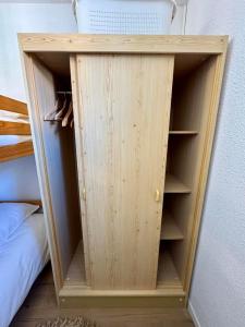 ein hölzernes Bücherregal in einer Ecke eines Schlafzimmers in der Unterkunft Charmant appartement vue mer in Le Barcarès + 2 Fotos