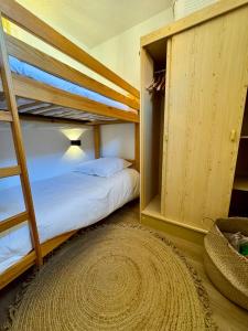 1 Schlafzimmer mit 2 Etagenbetten und einem Teppich in der Unterkunft Charmant appartement vue mer in Le Barcarès