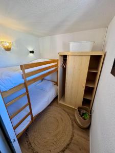 ein Schlafzimmer mit zwei Etagenbetten und einem Regal in der Unterkunft Charmant appartement vue mer in Le Barcarès