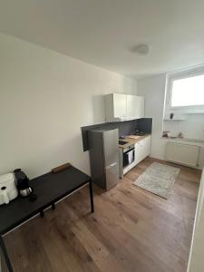 a white kitchen with a table and a refrigerator at gemütliche Wohnung in Witten in Witten +2 photos