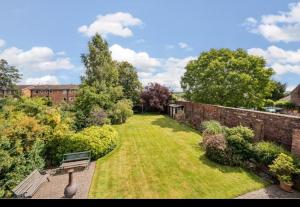 a garden with a bench and a brick wall at Mitton Villa in Stourport