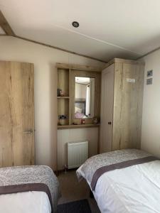 a bedroom with two beds and a window at 18 Bay View in Wyke Regis