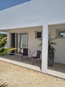 a patio with two chairs and a plant at Villa Nossa in Keur Goonde