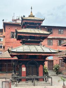 Ein Gebäude mit einer Pagode darüber. in der Unterkunft Yogi's Heritage in Patan - Heritage Studio Bhairabnath in Pātan