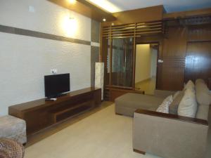 ein Wohnzimmer mit Sofa und Flachbildfernseher in der Unterkunft Neeshorgo Hotel & Resort in Cox's Bazar