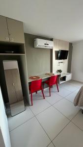a kitchen with a table and two red chairs at Flat Tambaú - Beira-mar in João Pessoa +11 photos