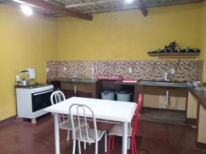 ヴァレ・ド・カパオンにあるQuarto para 6 a 900 metros da Vila do Capãoのキッチン(白いテーブル、椅子付)