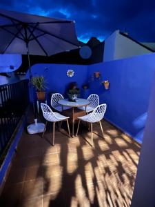 a patio with a table and chairs and an umbrella at Casa Morayma, Lecrin, Granada in Acequias