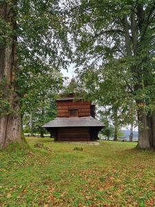 a small brick building in a park with trees at Dwerniczek 7 apartamenty in Dwerniczek +52 photos