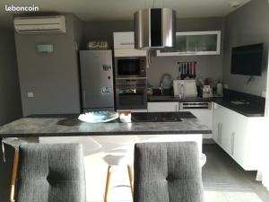 a kitchen with a counter and two chairs in it at Villa pool air-conditioning garage near golf in Salernes +6 photos