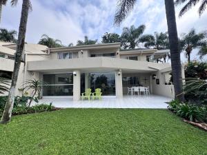 a large white house with a patio and lawn at Olives by Agnes 33 in Hartbeespoort
