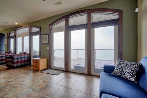 sala de estar con ventanas grandes y sofá azul en Blue View Chalets, en Blue Mountains 283 fotos más