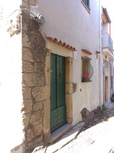 una porta verde sul lato di un edificio di la roccia a Cuglieri