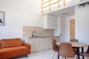 a kitchen and dining room with a couch and a table at Fabryka Loft 3B # Nestapartamenty in Bielsko-Biała