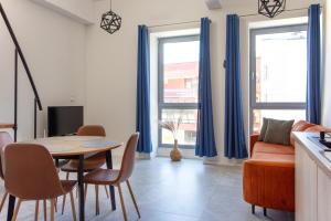 a kitchen and living room with a table and chairs at Fabryka Loft 3B # Nestapartamenty in Bielsko-Biała