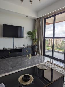 Una sala de estar con un televisor en la pared. en Taraja Comfort, en Nairobi 28 fotos más