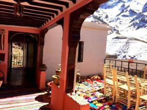 a room with a table and chairs and a mountain at Gite Likemte Tachdirt in Tacheddirt