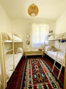 a bedroom with two bunk beds and a rug at Villa vista mare a Bosa in Magomadas