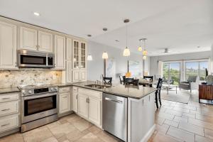 Una cocina grande con gabinetes blancos y un comedor. en 5131 Windswept Villa by Akers Ellis Rentals, en Kiawah Island