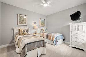 1 dormitorio con 2 camas, TV y tocador en 5131 Windswept Villa by Akers Ellis Rentals, en Kiawah Island