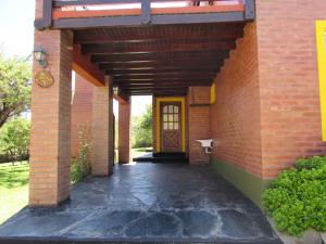 einen Eingang zu einem Backsteingebäude mit einer Tür in der Unterkunft Cabañas El Maiten in Merlo