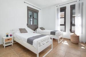 two beds in a white room with two windows at Villa Siegfried JÁVEA in Benitachell +30 photos