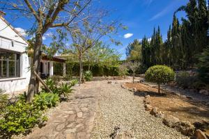 a garden with a stone path next to a house at Villa Siegfried JÁVEA in Benitachell