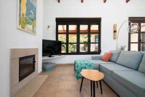 a living room with a blue couch and a fireplace at Villa Siegfried JÁVEA in Benitachell