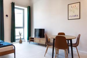 a living room with a table and chairs and a tv at Loft Fabryka Włókna 3c #nestapartamenty in Bielsko-Biała