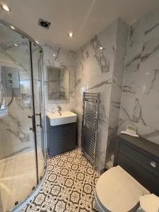 a bathroom with a shower and a toilet and a sink at Grangeview Guest House in Edinburgh +40 photos