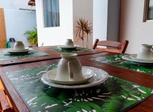 a wooden table with bowls and plates on it at Pousada Luar do gostoso in São Miguel do Gostoso