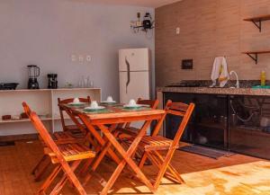 a kitchen with a table and chairs and a refrigerator at Pousada Luar do gostoso in São Miguel do Gostoso