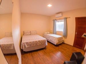 a bedroom with two beds and a window at Pousada Luar do gostoso in São Miguel do Gostoso