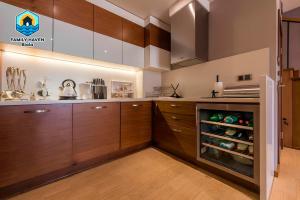 a kitchen with wooden cabinets and an open refrigerator at Вилла Biala family haven in Byala