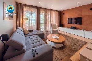 a living room with a couch and a television at Вилла Biala family haven in Byala