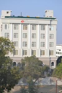 a white hotel building with a sign on it at The Legend in Allahābād