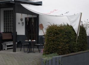 a patio with a table and a white awning at Ferienwohnung Körnernest in Ettringen
