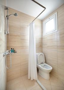 a bathroom with a toilet and a shower with a window at The Woodnest in Vonitsa +14 photos