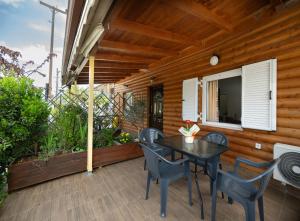a patio with a table and chairs and a television at The Woodnest in Vonitsa