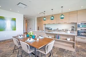 une cuisine avec une table et des chaises en bois dans l'établissement Family Fun & Luxury Andaz Penthouse Ocean & Sunset Views From Lanai Hot Tub 3 Br4 Ba For 8, à Wailea