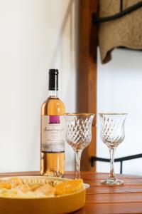 a bottle of wine and two wine glasses on a table at The Woodnest in Vonitsa