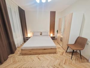 a bedroom with a bed and a chair in it at YaVi's Central Apartment in Veliko Tŭrnovo