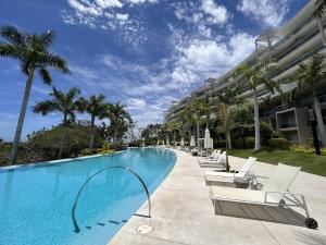 a swimming pool with lounge chairs and a building at Luxury Villa in Punta Mita in Higuera Blanca