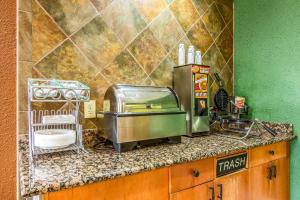 a kitchen with a counter with a sink and aounter at Econo Lodge Topeka at Wanamaker in Topeka