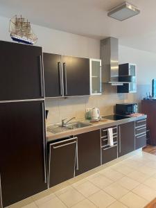 a kitchen with a sink and a refrigerator at Wave and Sun Apartment in Hel