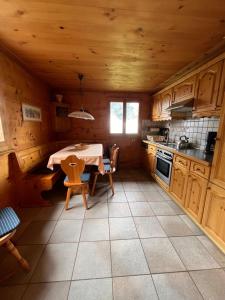 a kitchen with a table and a kitchen with wooden cabinets at Chalet Karin in Sankt Niklaus