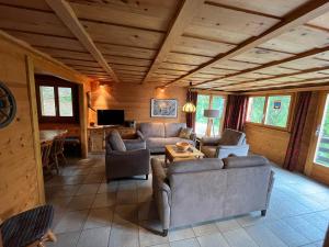 a living room with couches and a table in a cabin at Chalet Karin in Sankt Niklaus